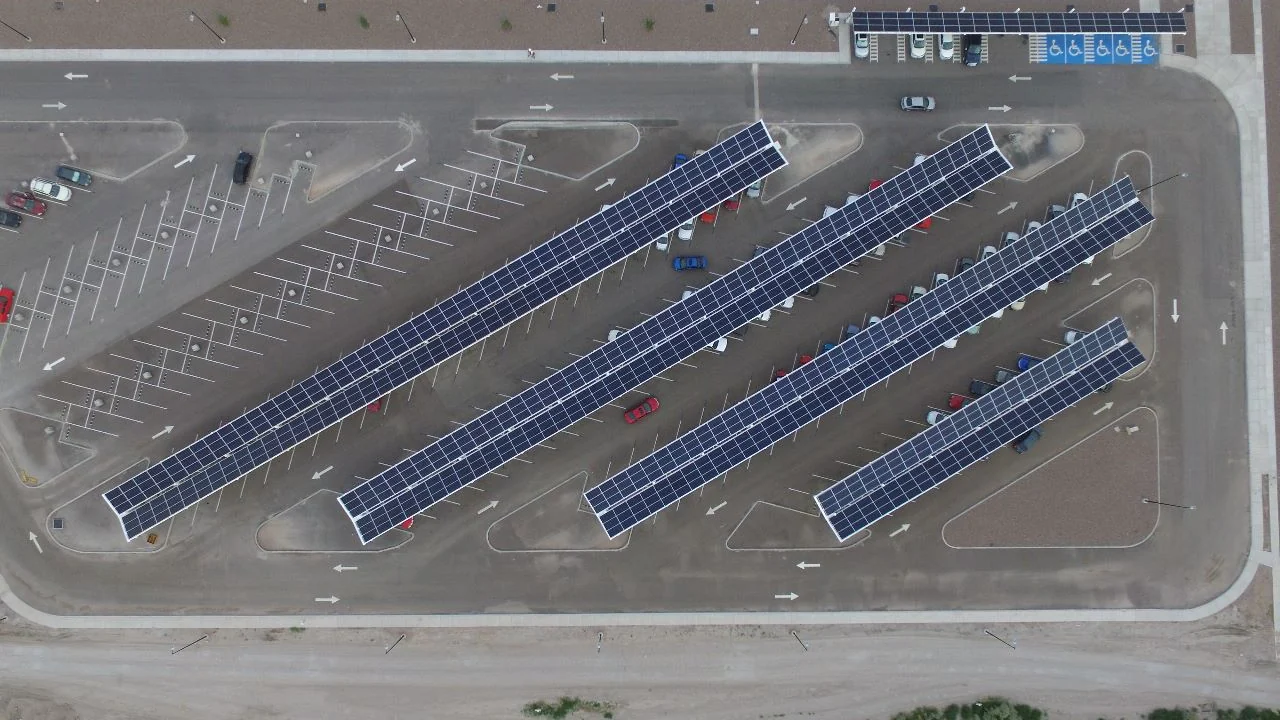 Vista aérea de filas de carports solares Energon sobre un estacionamiento